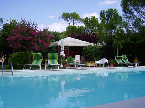 a group of lawn chairs and a swimming pool at Agriturismo Il Casale in Morrovalle