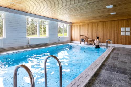a large swimming pool in a house with a wooden ceiling at House of Northern Senses in Ruka
