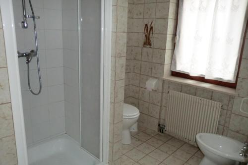 a bathroom with a shower and a toilet and a sink at Casa Erica - Carano in Carano