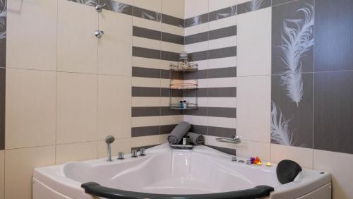 La salle de bains est pourvue d'une baignoire avec une chaise noire. dans l'établissement Villa Sophie, à La Canée