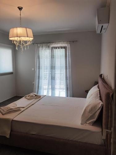 a bedroom with a bed with a chandelier and a window at Red in Vlikhón