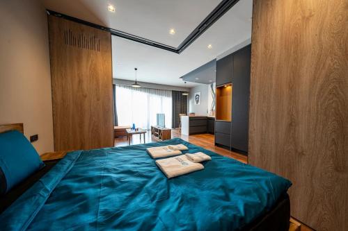 a bedroom with a blue bed with two towels on it at Classy, quality furnished residence-7/24 security ( Benesta 189 ) in Istanbul