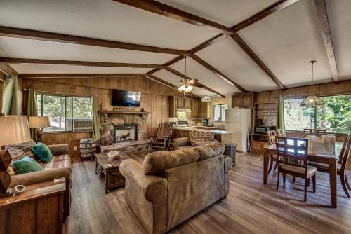 una sala de estar con sofás y una cocina en una casa en Pet Friendly Grizzly Blair Lodge Cabin, en Groveland