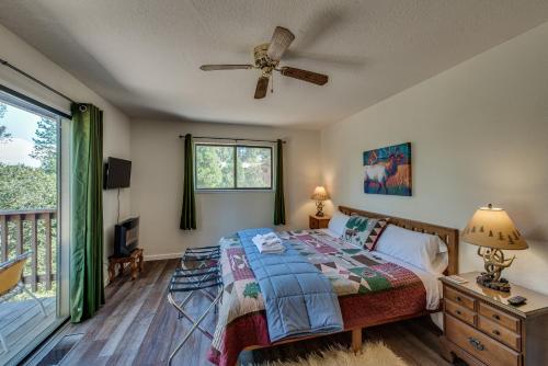 1 dormitorio con 1 cama y ventilador de techo en Pet Friendly Grizzly Blair Lodge Cabin, en Groveland
