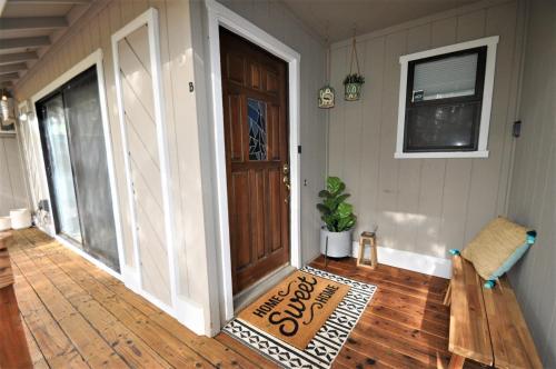 a porch with a welcome mat in front of a door at Gnome and Creek Yosemite Condo in Groveland