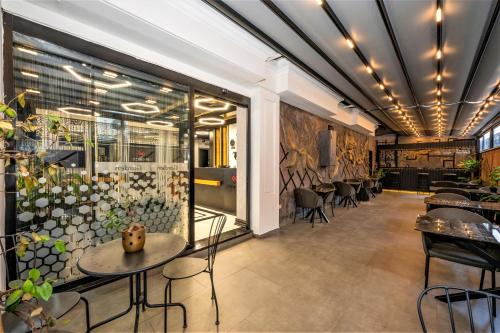 Confores Hotel في إسطنبول: مطعم فيه طاولات وكراسي في الغرفة