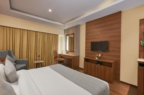 a hotel room with a bed and a flat screen tv at Southern Star,Bangalore in Bangalore