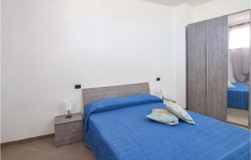 1 dormitorio con cama azul y espejo en Pet Friendly Apartment In Marina Di Strongoli With Wifi, en Marina di Strongoli