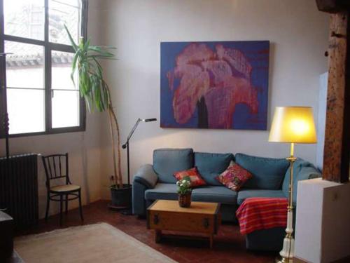 a living room with a blue couch and an elephant painting at El Arcon in Simancas
