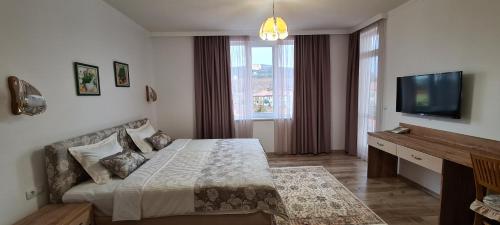 a bedroom with a bed and a flat screen tv at Aparthotel Olympus Plaza - SPA & Indoor Pool in Kranevo