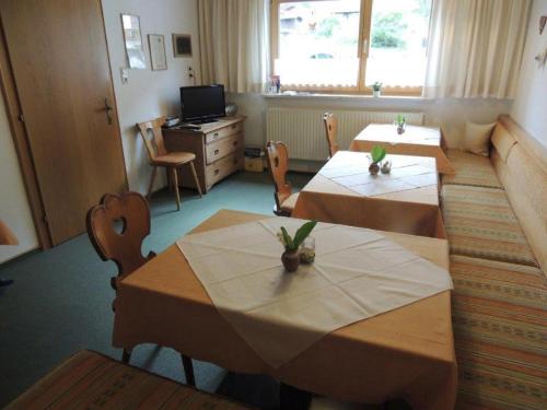 a dining room with two tables and a television at Haus Müller in Reutte
