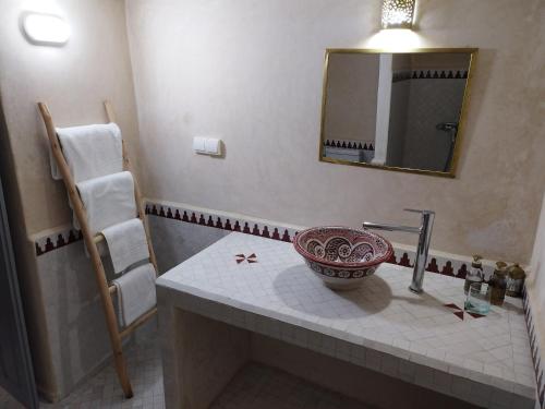 a bathroom with a sink and a mirror at RIAD MAROSKO in Essaouira