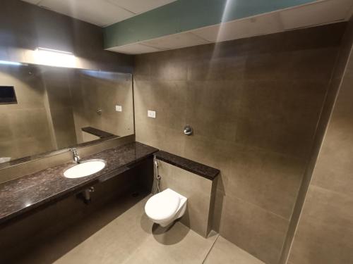 a bathroom with a toilet and a sink at Hotel Comorin Grand in Kanyakumari