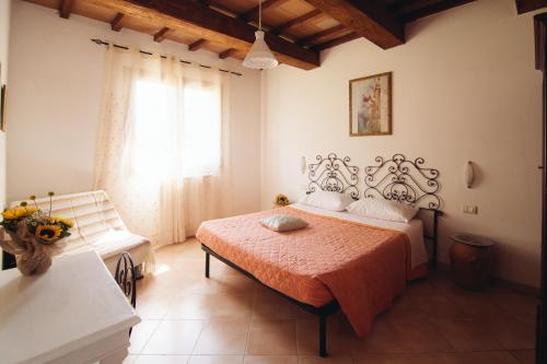 a bedroom with a bed and a window at Agriturismo Le Giare in Bagno Roselle