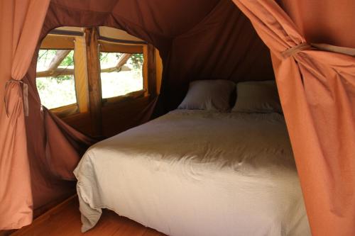 a bedroom with a bed in a tent at Chez Tombivouac in Pierrefonds