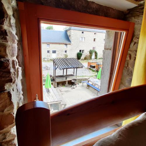 a window in a room with a view of a patio at La Ferme de Werpin in Hotton