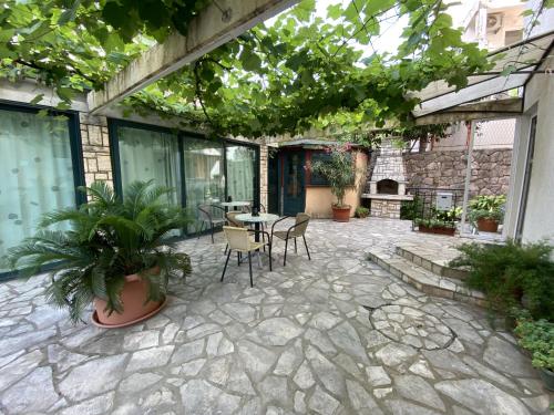 eine Terrasse mit einem Tisch, Stühlen und Pflanzen in der Unterkunft Alina's apartment in Becici