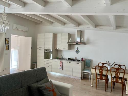 een woonkamer met een bank en een tafel en een keuken bij B&B dell'orologio in Acquaviva delle Fonti