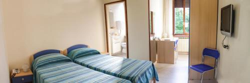 a hospital room with two beds and a television at Al Ponte della Vittoria in Belluno