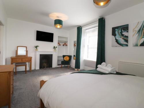 a bedroom with a bed and a fireplace and a television at Aryelle House in Kendal