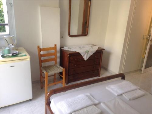 a bedroom with a bed and a dresser and a chair at Studio Stella in Plakias