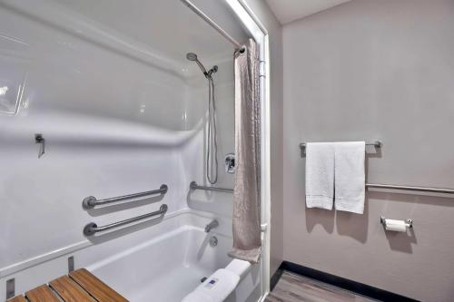 a bathroom with a tub and a shower with towels at Motel 6-Benbrook, TX - Fort Worth in Benbrook