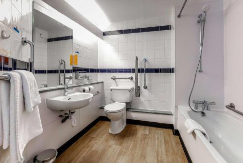 a bathroom with a toilet and a sink and a tub at Days Inn Warwick Northbound M40 in Warwick