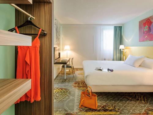 ein Hotelzimmer mit einem weißen Bett und einem Schreibtisch in der Unterkunft ibis Styles Speyer in Speyer