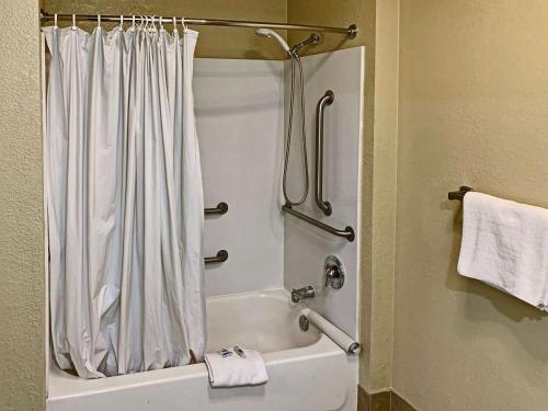 Rodeway Inn Sacramento-University Area في سكرامنتو: حمام مع ستارة دش وحوض استحمام