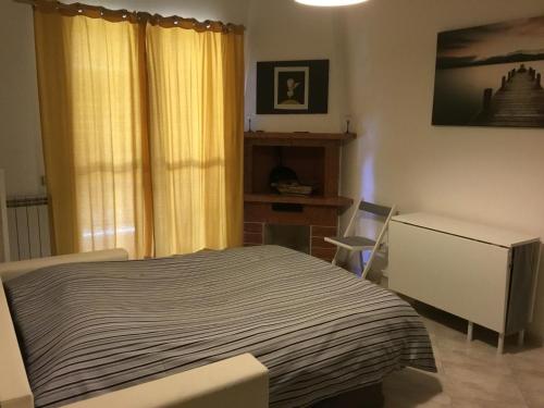 a bedroom with a bed and a desk and a window at Appartamento a Marina di San Nicola Roma in Palo