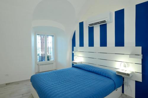 新布薩娜的住宿－A marina on Bussana Sanremo seaside，蓝色和白色的卧室,配有蓝色和白色的床头板