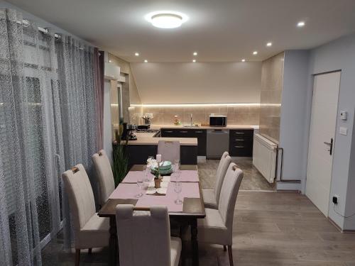 a dining room with a table and chairs and a kitchen at Apartman President in Krapinske Toplice