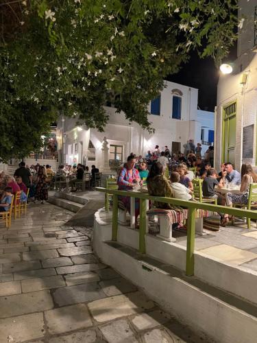 a group of people sitting at an outdoor restaurant at Amedi Villas Tinos in Pánormos