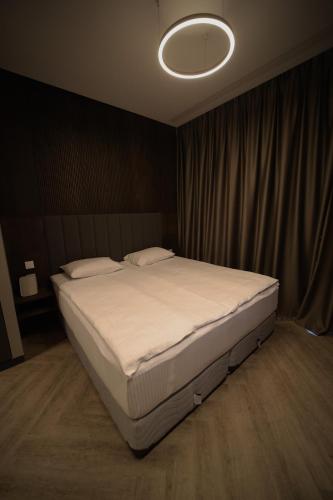 a bedroom with a large bed with a light on it at AVENUE RESIDENCE by AY North Avenue in Yerevan