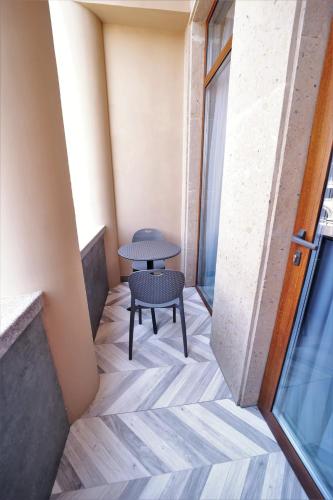 a table and a chair in a room with a window at AVENUE RESIDENCE by AY North Avenue in Yerevan