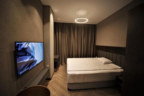 Schlafzimmer mit einem Bett und einem Flachbild-TV in der Unterkunft AVENUE RESIDENCE by AY North Avenue in Yerevan