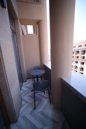 a small table and two chairs in a room with a window at AVENUE RESIDENCE by AY North Avenue in Yerevan