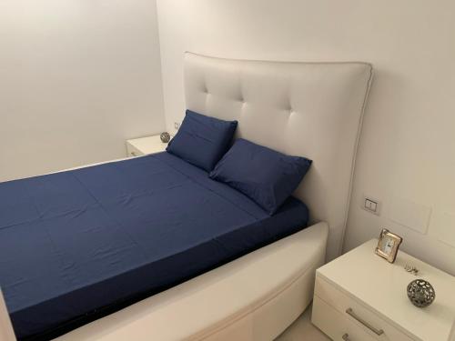 een bed met blauwe kussens in een kleine kamer bij Villa luxury con piscina in Mesagne