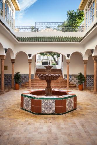 a courtyard with a fountain in the middle of a building at Grand Hotel Villa de France in Tangier
