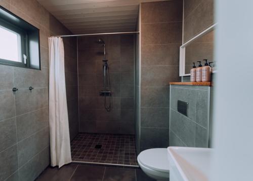 a bathroom with a shower and a toilet at Heima Holiday Homes in Selfoss