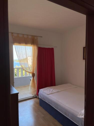 um quarto com uma cama e uma janela com uma varanda em Apartman Jole em Razanj