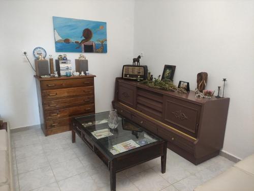 a living room with a dresser and a glass table at Olive tree house in Sozopoli