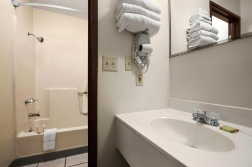Baño blanco con lavabo y espejo en Super 8 by Wyndham Concordia, en Concordia