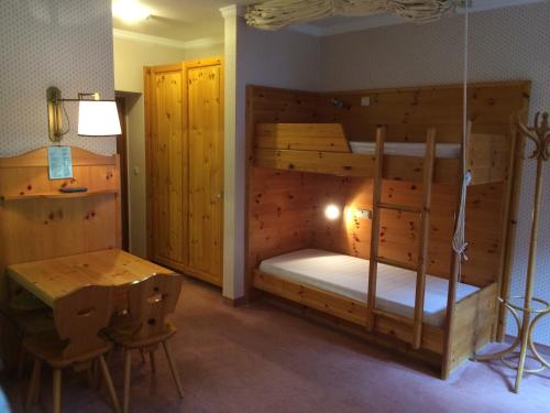 Villaggio Turistico Ploner في كاربونين: غرفة نوم مع سرير بطابقين مع مكتب وطاولة