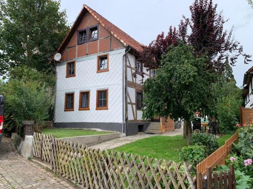 een wit huis met een hek ervoor bij Bike & Sleep Weserbergland Ferienhaus in Vahlbruch