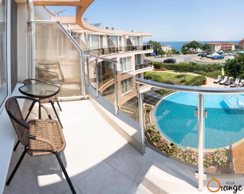 a balcony with a table and a swimming pool at Villa Orange in Sozopol