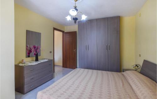a bedroom with a large bed with a dresser and a cabinet at Amazing Apartment In Ricadi With House Sea View in Ricadi