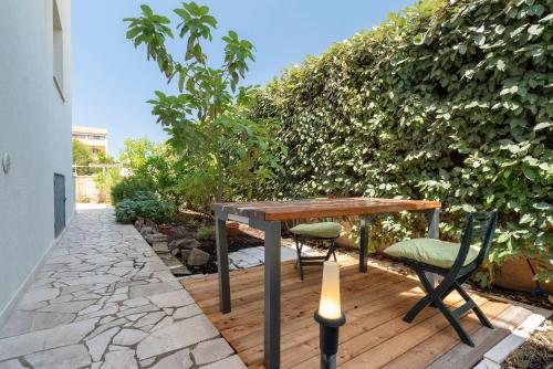 フェルティリアにあるCharming Seafront Apartment with garden and patioの木製テーブルと椅子付きのパティオ