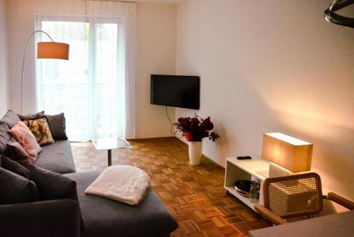 ein Wohnzimmer mit einem Sofa und einem TV in der Unterkunft StellaStudio in Hamburg