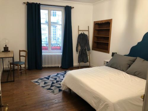a bedroom with a bed and a window at Les 3 p’tites pom’s in Alençon